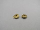 a pair of brass plated beads on a gray surface