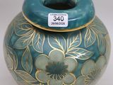 a blue and gold vase sitting on a white table