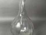 a clear glass bottle with a handle on a table