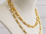 a gold chain necklace on a mannequin with a white background