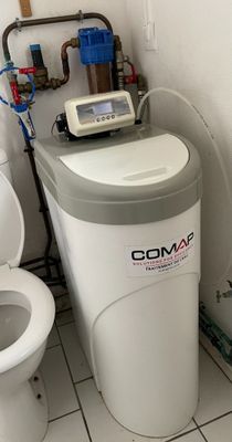 des toilettes blanches et un adoucisseur d'eau dans une salle de bains