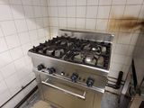 une cuisine sale avec une cuisinière et une plaque de cuisson