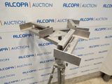a close up of a metal object on a tripod in front of a wall