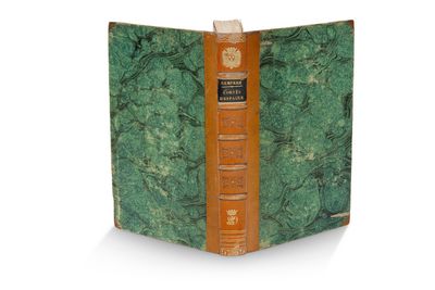 un vieux livre à la couverture verte posé sur une surface blanche
