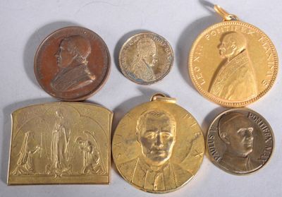 several different types of coins and medals are displayed on a white surface