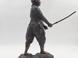 statue of a man with a sword on a rock
