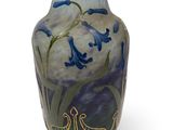 un vase orné de fleurs bleues sur fond blanc