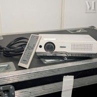 a projector sitting on top of a case with a remote