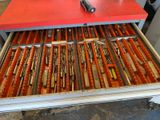 a drawer full of knives in a kitchen with a red table