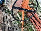 une bétonnière posée à côté d'un tas de bois