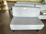 a white couch sitting in a room with a mirror on the wall