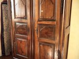 a large wooden armoire in the corner of a room