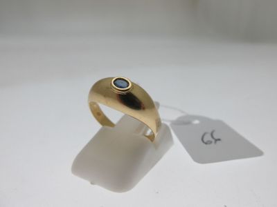 l'image d'une bague en or ornée d'une pierre bleue
