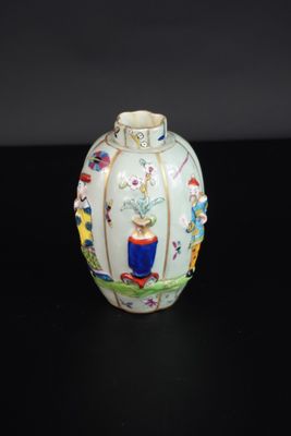 un vase blanc orné de motifs colorés sur un fond noir