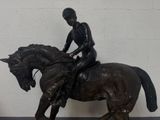 a bronze statue of a man riding a horse