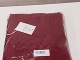 a bag of red cloth on a table next to a bottle of wine