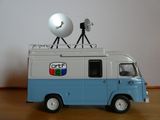 une camionnette miniature sur le toit de laquelle est posé un satellite