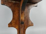 an old wooden stool with a wooden seat on top of it