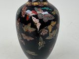 un vase noir orné d'un motif de papillon