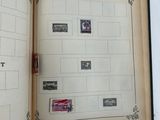 someone is holding a book with stamps on it and a stamp holder