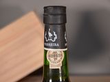 a bottle of wine sitting on a table next to a bottle of wine