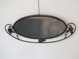 un miroir accroché au mur, avec un cadre en métal