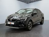 Une voiture noire est garée dans une grande pièce aux murs blancs.