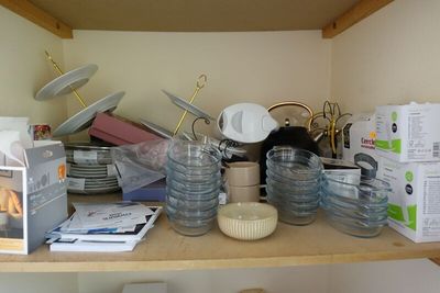 a wooden shelf with a lot of dishes and bowls on it