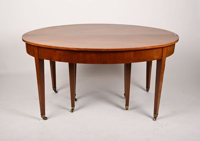 une table de salle à manger ovale avec quatre pieds et un plateau en bois