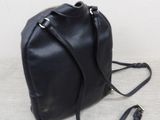 black leather bucket bag with gold chain strap on a white background