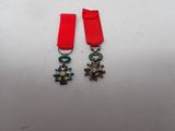 two medals with a red ribbon and a cross on them
