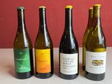 quatre bouteilles de vin sont alignées sur une table