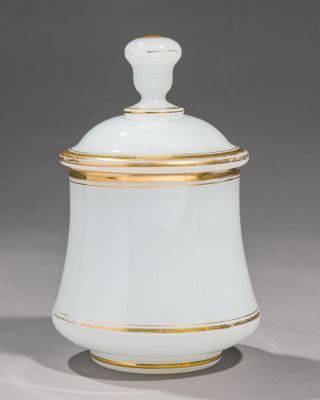 un pot recouvert de blanc et d'or, avec un rebord doré