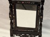 a mirror that is sitting on a stand on a white background