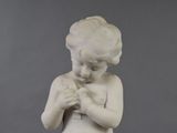 a statue of a child holding a bird in his hands
