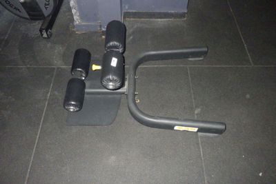 un appareil de musculation posé par terre à côté d'un sac