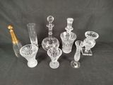 six glass vases and a bottle of champagne on a black background