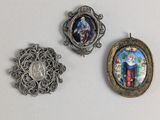 trois bijoux sont présentés sur une surface blanche