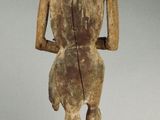 statue of a man standing on a wooden block with his back turned to the camera