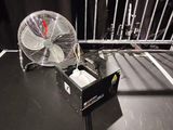 un ventilateur posé sur une table devant une clôture