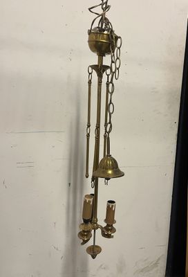 une horloge en laiton accrochée au mur, à côté d'un rideau noir