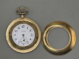 une montre de poche en or et une bague en or posées sur une table