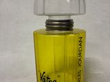 a yellow bottle of perfume on a white surface