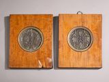 deux plaques en bois ornées d'un médaillon en argent, accrochées à un mur