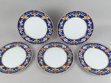 un service de quatre assiettes bleues et dorées ornées de motifs floraux