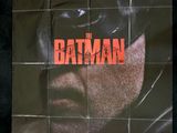 the batman movie poster on a wall in a dark room