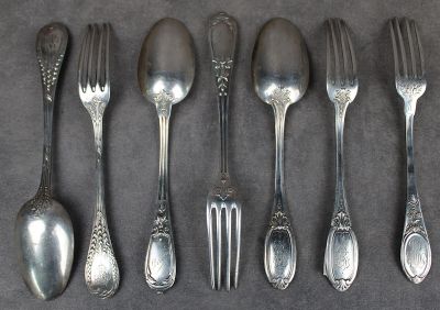 cinq fourchettes et cinq cuillères sur la table