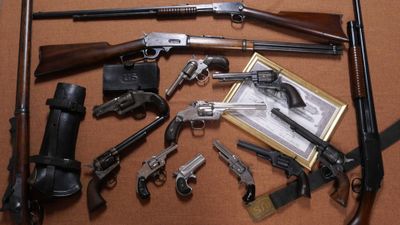 tout un tas d'armes à feu posées sur une table