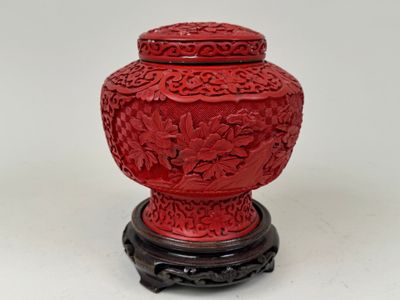 a red vase that is sitting on a stand