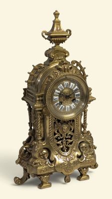 une horloge en or posée sur une surface blanche